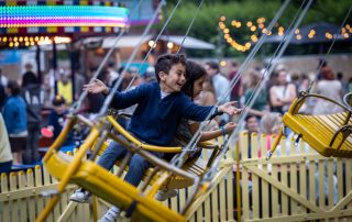 Zweefmolen in bedrijf met kinderen en bezoekers