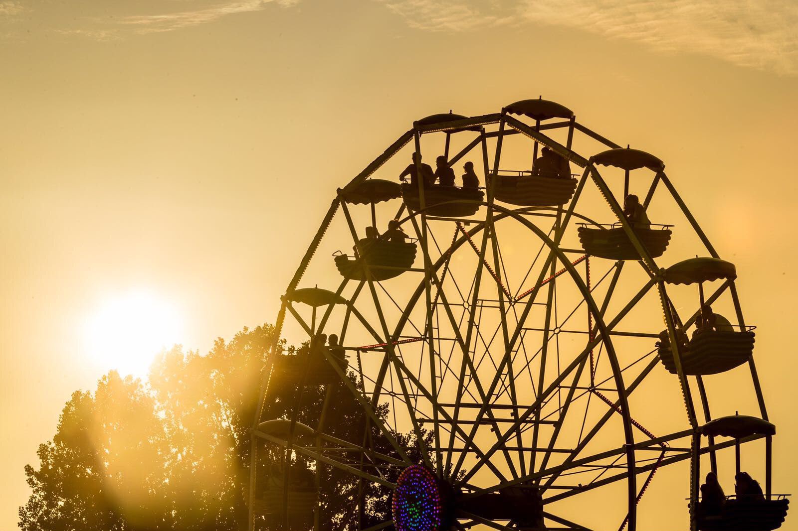 Reuzenrad Silhouet van reuzenrad met gondels tegen een oranje avondlucht bij zonsondergang